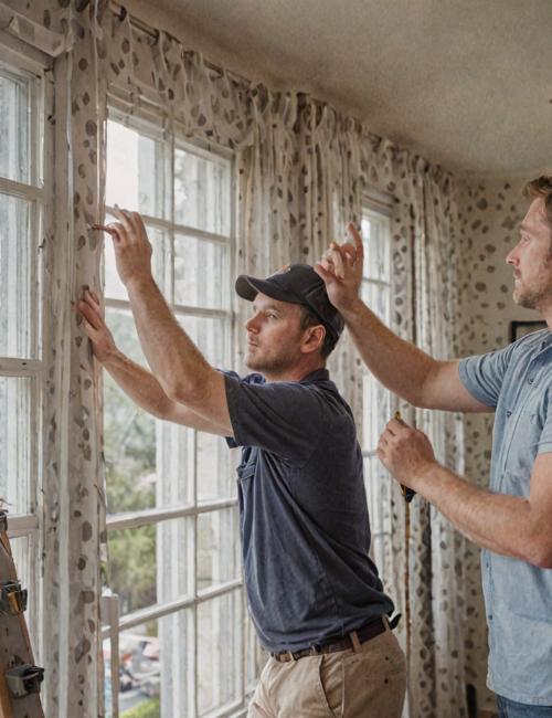 Professional team working on window blinds installation